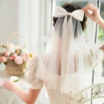 우아한 새틴 리본매듭 짧은 신부 베일 부드러운 얇은 명주 그물 어깨 길이 웨딩 베일 빗 포함